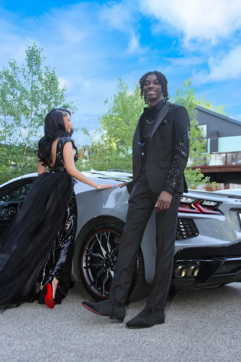 Prom couple posing with a sports car